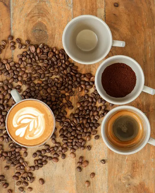 Espresso, cappuccino and coffee beans on a wooden table