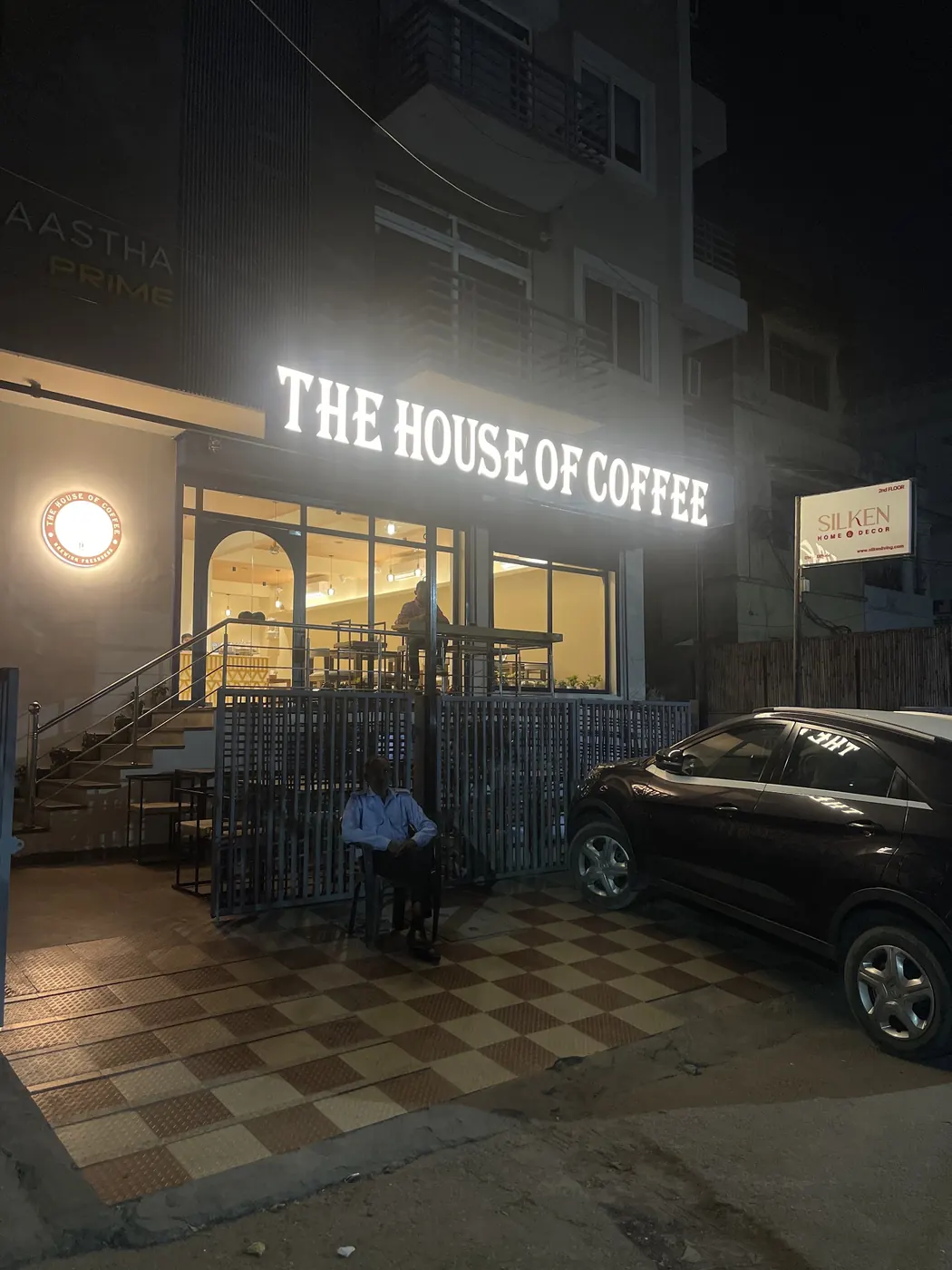 The House of Coffee storefront lit up at night